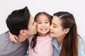 Portrait of attractive asian family kissing cheek together close up on isolated white studio background. Gen alpha and millennials