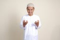 attractive Asian muslim man in white shirt making angry hand gesture with fingers. Isolated image on gray background Royalty Free Stock Photo