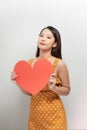 Portrait of attractive asian smiling woman holding red heart on white background Royalty Free Stock Photo