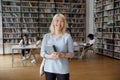 Portrait of attractive Asian student girl standing in campus library