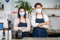 Portrait of attractive Asian waiter and waitress at restaurant cafe. Barista business couple in apron wearing protective mask , Royalty Free Stock Photo
