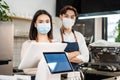 Portrait of attractive Asian waiter and waitress at restaurant cafe. Barista business couple in apron wearing protective mask , Royalty Free Stock Photo