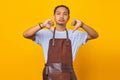 Portrait of attractive Asian young man wearing apron unhappy and angry showing rejection with thumbs down gesture Royalty Free Stock Photo