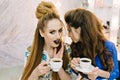 Portrait attractive astonished gossip women with cups of coffee communicating in haidresser salon. Having fun, stylish Royalty Free Stock Photo