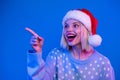 Portrait of attractive astonished person look direct finger empty space x-mas eve offer isolated on blue color neon