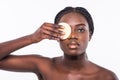 Portrait of attractive beautiful black african woman holding a make up sponge to her cheek, beauty skincare. cosmetics concept Royalty Free Stock Photo