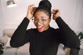 Portrait of attractive black woman smiling and happy on white background wearing a black top sitting on sofa Royalty Free Stock Photo