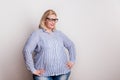 Portrait of an attractive overweight woman with glasses in studio.