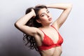 Attractive woman collecting wavy hair and looking at camera with passion, wearing red sexy lingerie. Royalty Free Stock Photo