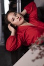 Portrait of attractive brunette woman in red blouse lying on leather couch. st valentines Royalty Free Stock Photo