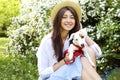 Attractive hipster young woman went for a walk in the park, playing with cute jack russell terrier puppy on clear sunny day. Royalty Free Stock Photo