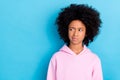 Portrait of attractive bushy haired skeptic girl looking aside copy space no isolated over bright blue color background