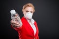 Portrait of attractive business woman handing water wearing mask
