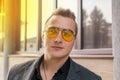 Portrait of attractive businessman of Caucasian appearance in sunglasses and jacket on street outdoor Royalty Free Stock Photo