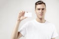 Portrait of attractive businessman holding blank business card, empty space for layout, with white background. Focus on card. Royalty Free Stock Photo