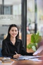 Attractive businesswoman sitting at her office desk and smiling to camera. Royalty Free Stock Photo