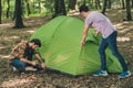 Portrait of attractive busy focused two guys traveling exploring wild park setting tent active lifestyle weekend