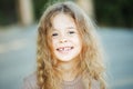 Portrait of attractive caucasian little child girl with blond curly hair and cute smile. Royalty Free Stock Photo