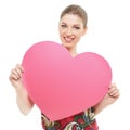 Portrait of attractive caucasian smiling woman holding big pink heart blank for love message for Valentine`s day, on