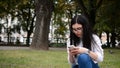 Portrait Of Attractive CaucasianWoman Smiling Brunette Typing Sms In Park