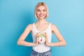 Portrait of attractive cheerful blond girl holding in hands childish clock isolated over bright blue color background Royalty Free Stock Photo