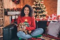 Portrait of attractive cheerful careful girl spending advent evening rest sitting on divan playing with puppy at home