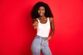 Portrait of attractive cheerful confident coquettish girl posing pointing at you isolated over bright red color