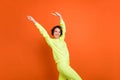 Portrait of attractive cheerful dreamy carefree girl good mood having fun dancing isolated over vibrant orange color