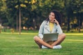 Portrait of attractive cheerful dreamy girl sitting on grass using laptop watching video film movie pastime outdoor Royalty Free Stock Photo