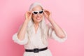 Portrait of attractive cheerful dreamy grey-haired woman touching specs adventure isolated over pink pastel color Royalty Free Stock Photo