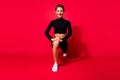 Portrait of attractive cheerful endurant strong girl doing sit ups crossfit isolated over bright red color background Royalty Free Stock Photo