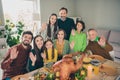 Portrait of attractive cheerful family eating domestic dish meeting festal occasion event waving hi hello at home