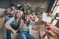Portrait of attractive cheerful friends eating snack gathering showing thumbup taking selfie in house loft brick style