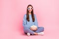 Portrait of attractive cheerful funky girl sitting lotus pose eating corn pastime isolated over pink pastel color