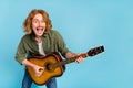 Portrait of attractive cheerful funky guy playing guitar rock hit singing having fun isolated over pastel blue color Royalty Free Stock Photo