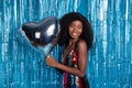 Portrait of attractive cheerful girl holding in hands silver air ball heart cupid date clubbing over blue