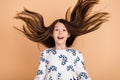 Portrait of attractive cheerful girl silky long hair flying good mood isolated on beige pastel color background Royalty Free Stock Photo