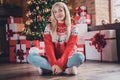 Portrait of attractive cheerful girl sitting on floor resting festal day december winter at modern brick loft industrial