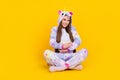 Portrait of attractive cheerful girl sitting lotus pose eating hugging corn spending free time isolated over bright