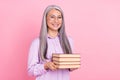 Portrait of attractive cheerful gray-haired woman holding science books isolated over pink pastel color background Royalty Free Stock Photo