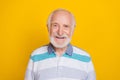 Portrait of attractive cheerful grey haired man smiling friendly wearing striped shirt isolated over vivid yellow color