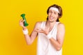 Portrait of attractive cheerful guy holding in hand little small dumbbell mocking isolated over bright yellow color Royalty Free Stock Photo