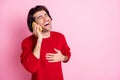 Portrait of attractive cheerful guy talking on phone laughing funny news copy space advert isolated over pink color