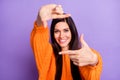 Portrait of attractive cheerful long-haired girl showing frame making snap posing model isolated over bright violet Royalty Free Stock Photo