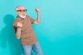 Portrait of attractive cheerful lucky grey-haired man having fun rejoicing isolated over bright blue color background