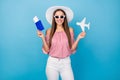 Portrait of attractive cheerful straight-haired girl holding in hand paper plane document isolated over bright blue Royalty Free Stock Photo