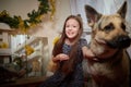 Portrait of attractive cheerful young girl resting festal day december winter in room decorated for Christmas with big Royalty Free Stock Photo