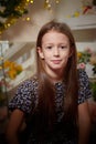 Portrait of cheerful young girl resting festal day december winter in room decorated for Christmas. Child in Royalty Free Stock Photo