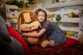 Portrait of attractive cheerful young girl resting festal day december winter in room decorated for Christmas. Child in Royalty Free Stock Photo