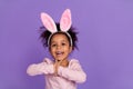 Portrait of attractive cheery cute amazed pre-teen girl wear bunny ears having fun isolated over bright purple violet Royalty Free Stock Photo